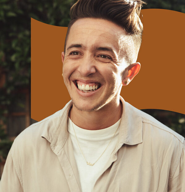 A transgender person smiling in the sunset.