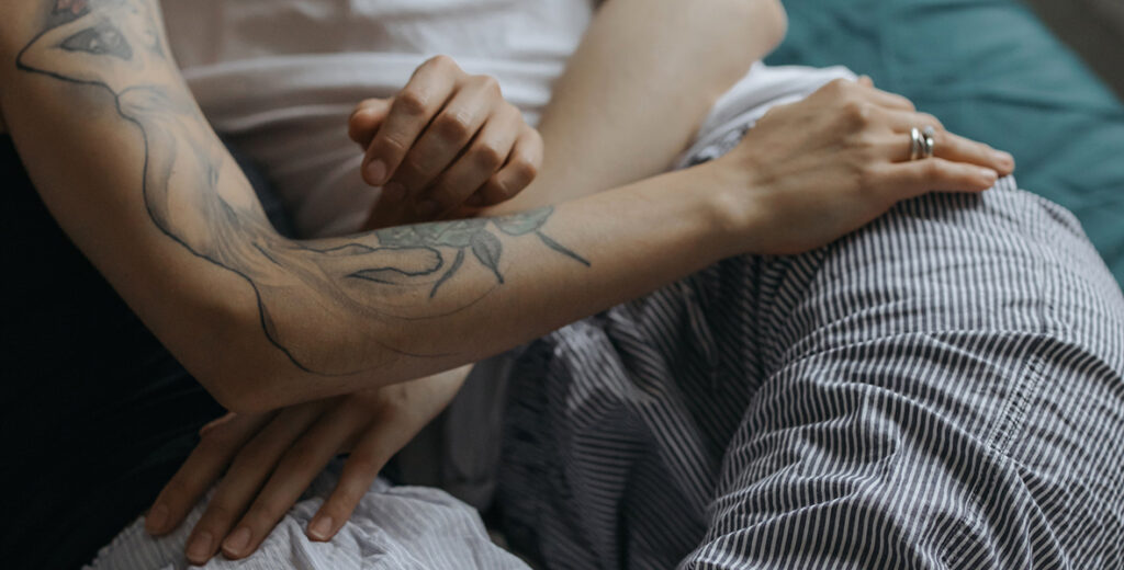 Couple laying in bed - close up of hand on the hip