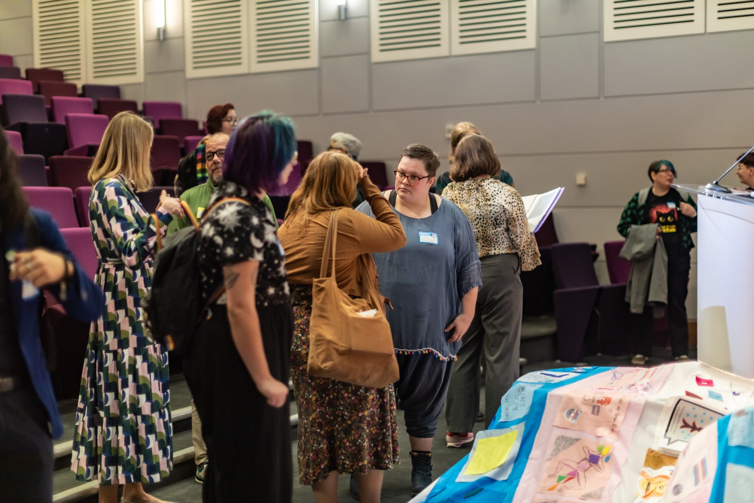 Attendees interacting and watching the zine exhibition during lunch