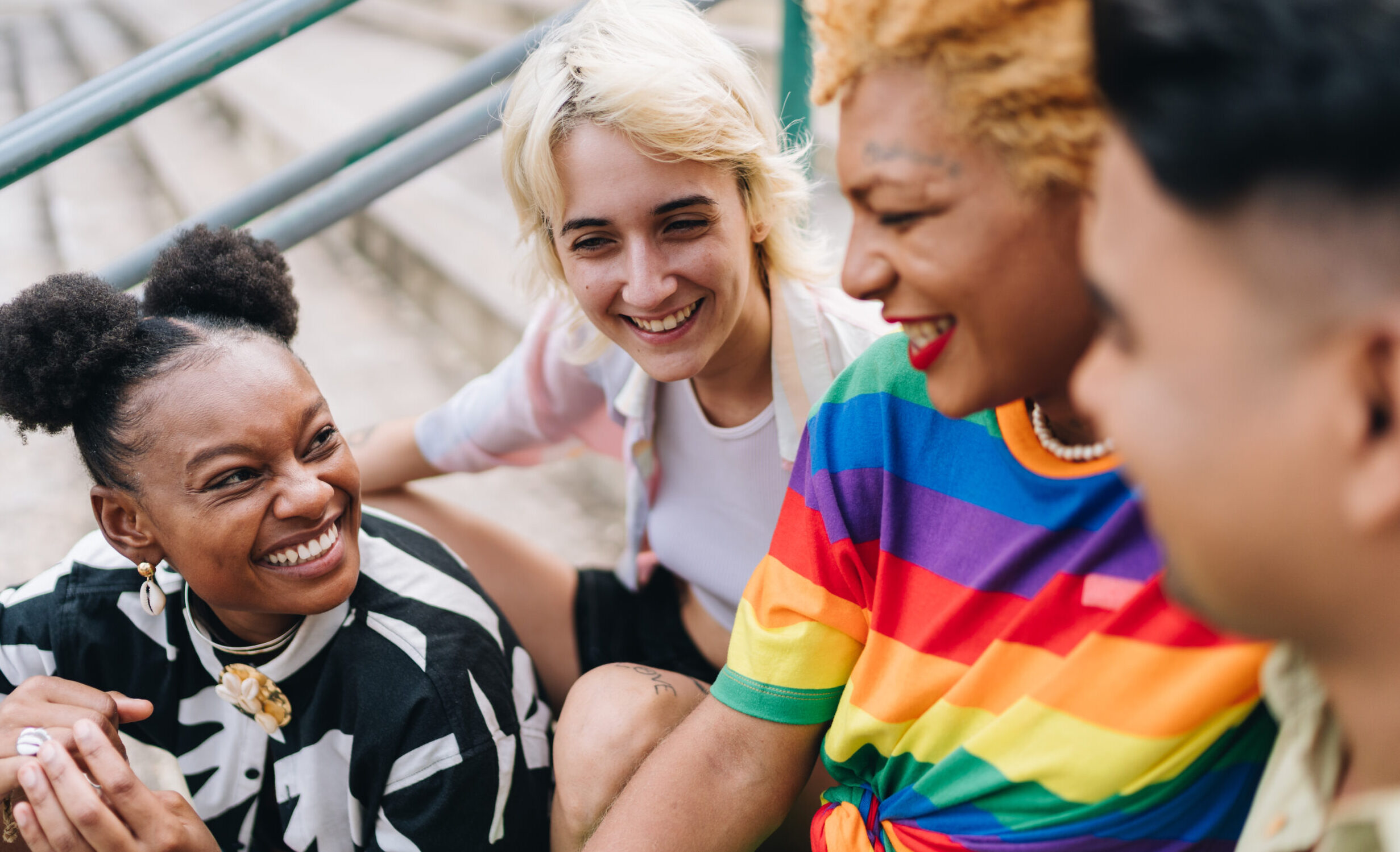 Lgbtqia+ friends talking sitting on a staircase outdoors